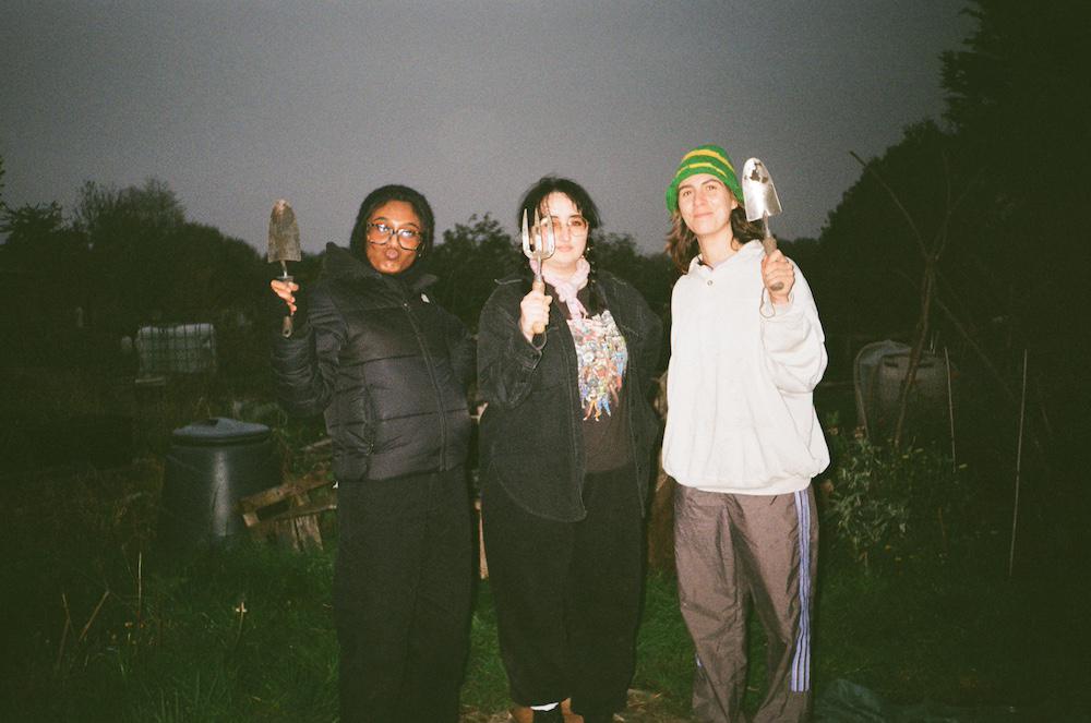 zarina gab and flo holding up gardening equipment in the dark