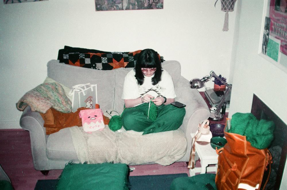 gab with her head down knitting on a couch