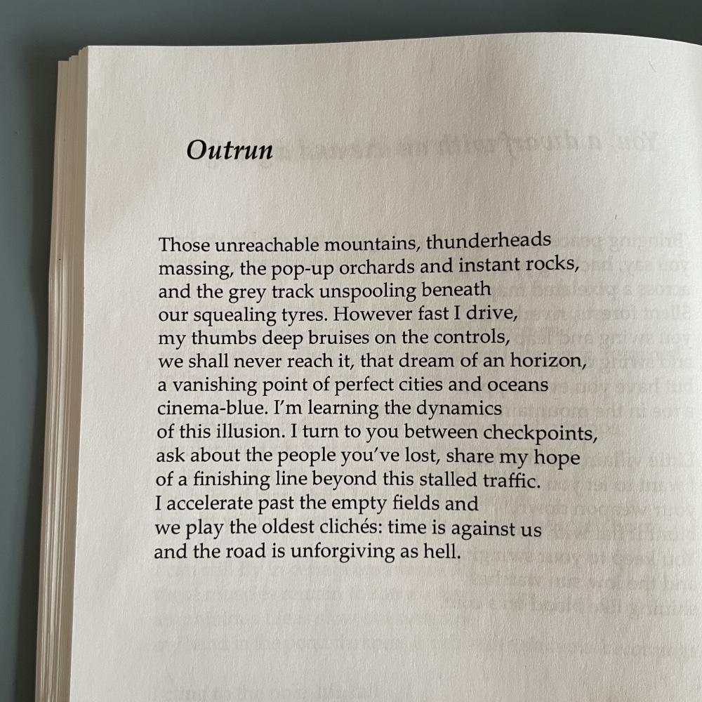a poem by Samuel Tongue reads: Those unreachable mountains, thunderheads massing, the pop-up orchards and instant rocks, and the grey track unspooling beneath our squealing tyres. However fast I drive, my thumbs deep bruises on the controls, we shall never reach it, that dream of an horizon, a vanishing point of perfect cities and oceans cinema-blue. I'm learning the dynamics of this illusion. I turn to you between checkpoints, ask about the people you've lost, share my hope of a finishing line beyond this stalled traffic. I accelerate past the empty fields and we play the oldest clichés: time is against us and the road is unforgiving as hell