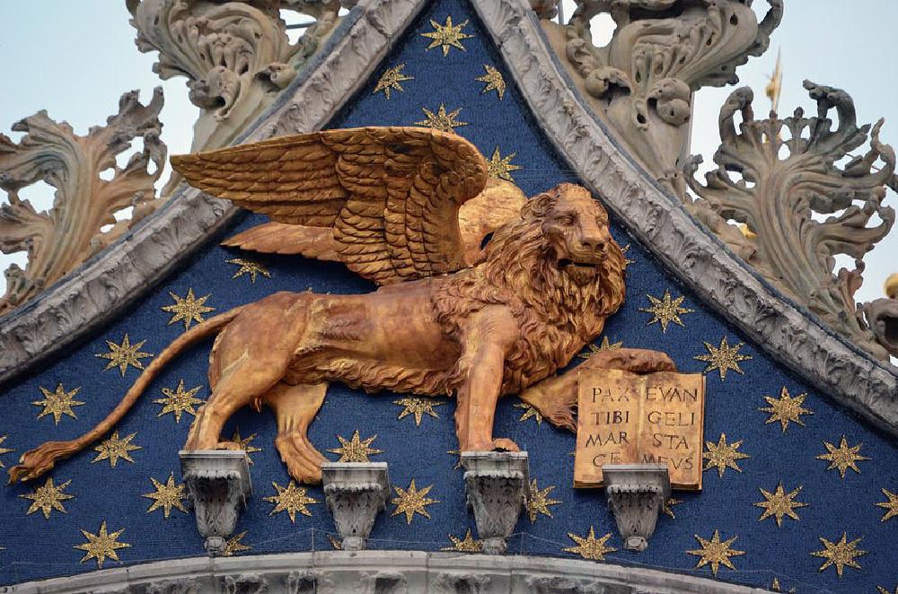 a winged golden lion statue on the outside of a chairs in the same pose as coco