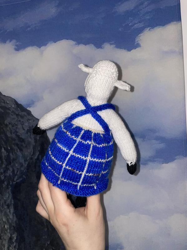 gab holds the sheep toy from behind so you can see a cross back strap on the dress