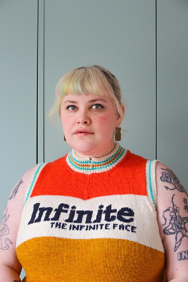 lydia is wearing a zipped up knitted racing jersey which is sleeveless