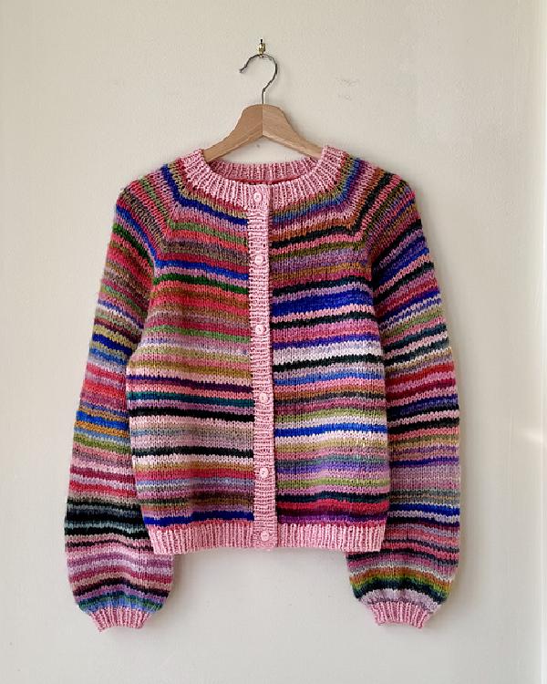 a stripy cardigan in pink and purple and red tones with a big of blue and a solid pink button band