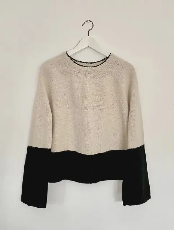 a simple beige jumper but the bottom of the bottom and the bottom of the sleeves are black