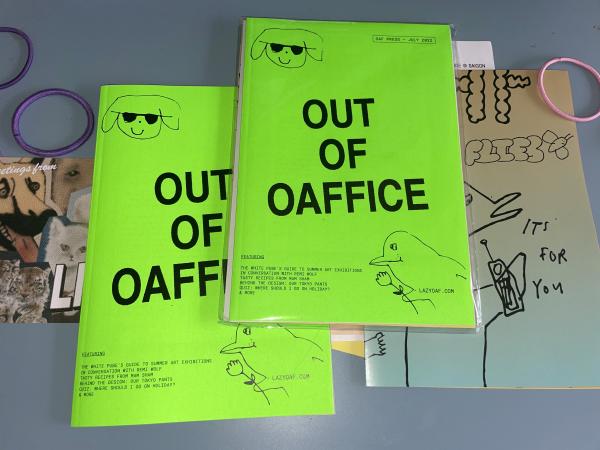 flatlay of the lazy oaf neon green zine on gab's desk saying it contains a summer exhibition guide, an inerview with remi wolf, recipes, and quizzes