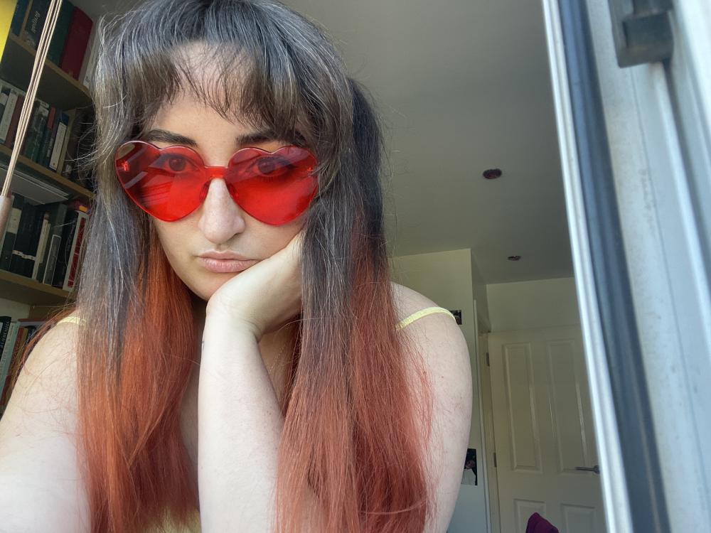 gab wearing red plastic heart shaped glasses