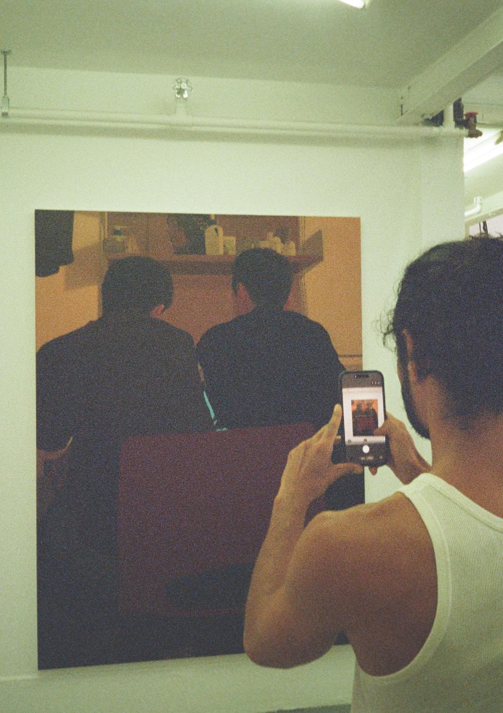 SEBASTIAN espejo taking a photo on his phone of a painting