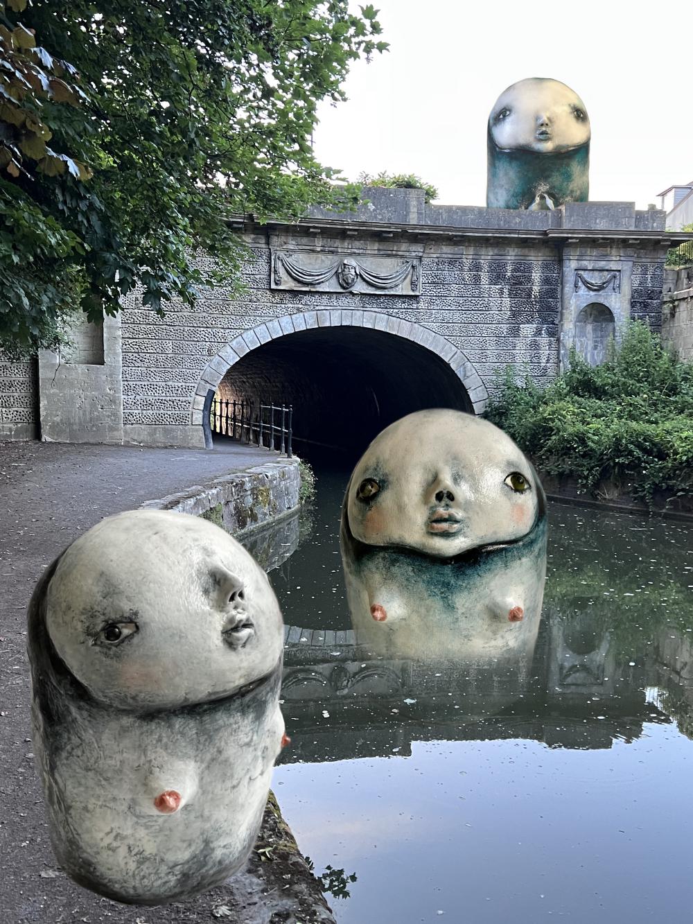 round sculptures with wide faces and nipples superimposed at the edge of a canal, in the water, and on a bridge overtop