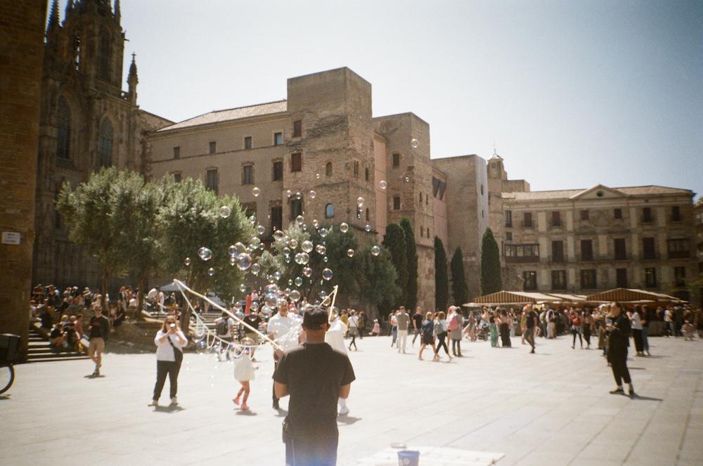 a street entertainer with one of those big dangling ropes that drags through water and up into the air to create a big cloud of bubbles for kids to play in