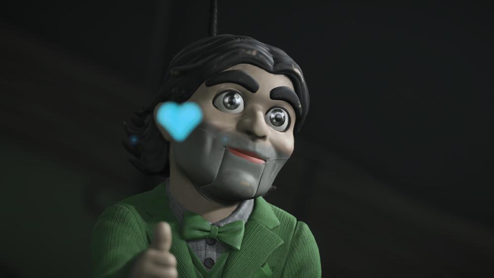the puppet dollman puts a thumbs up and a blue heart appears about his hand