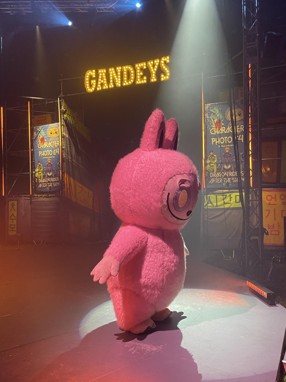 in the empty gandey's circus ring a giant pink labubu mascot is stood waiting for kids to take pictures with it